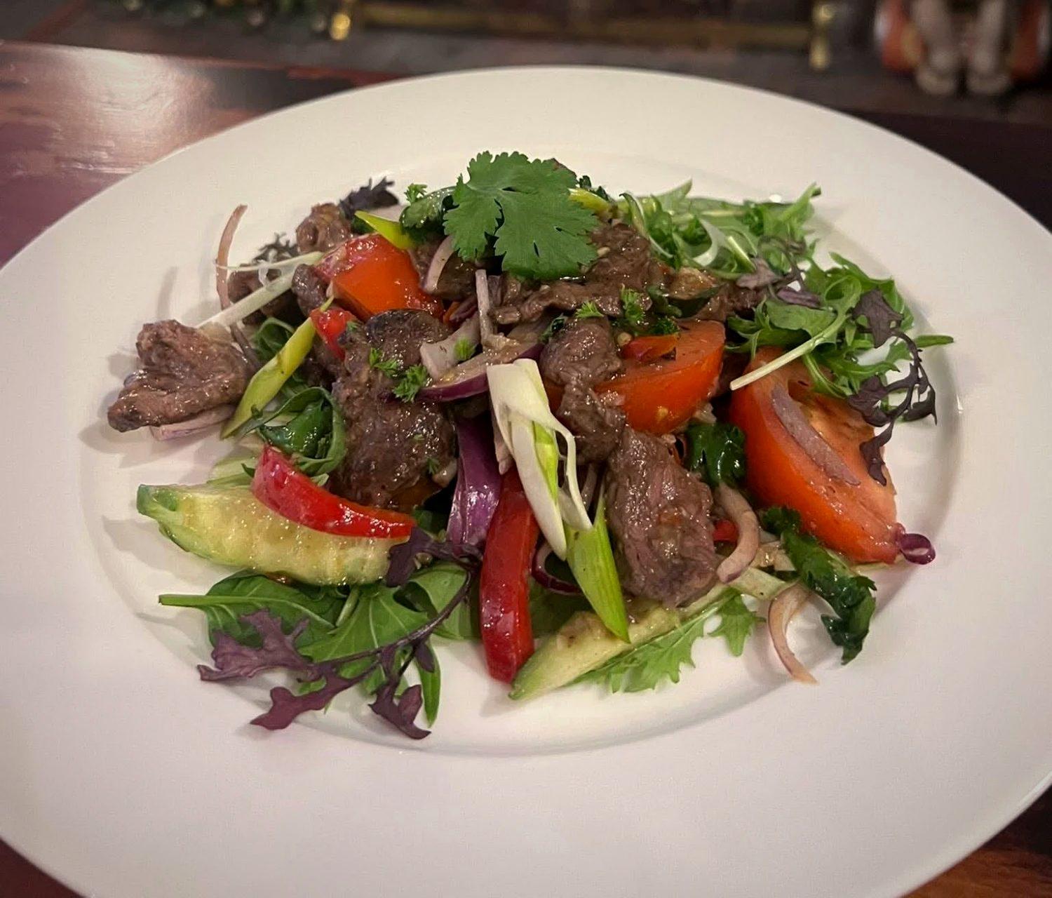 Yum beef salad with tomato, red onion and fresh herbs